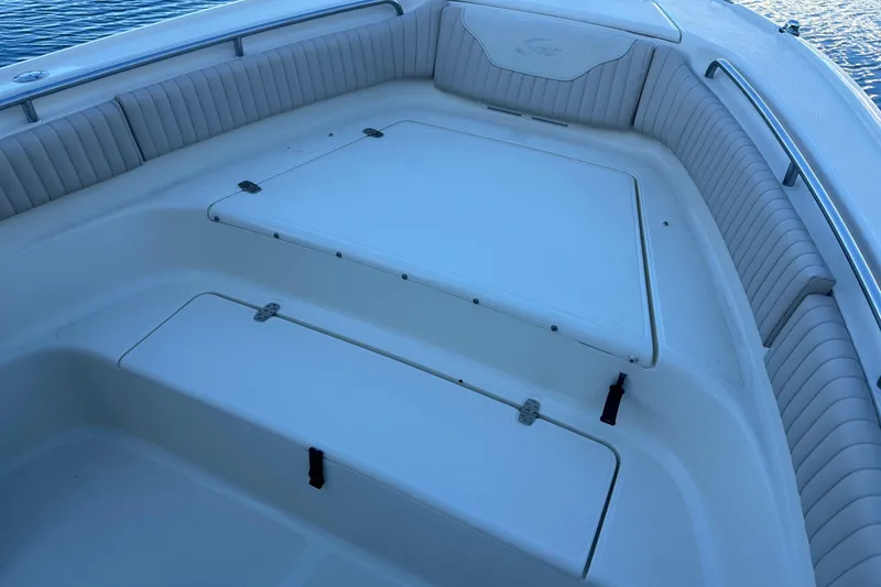 Slide: The Image of 2004 Scout 235 Sportfish boat interior with cushioned seating and storage compartments. - 10