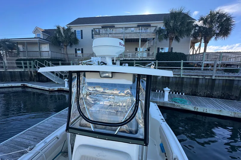 Slide: The Image of 2004 Scout 235 Sportfish boat docked near waterfront home with palm trees. - 16
