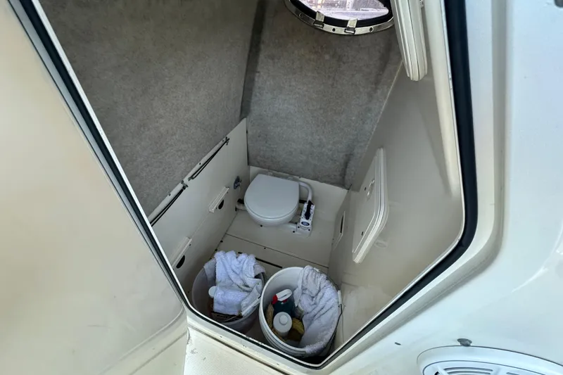 Slide: The Image of 2004 Scout 235 Sportfish boat interior with toilet and storage buckets. - 18