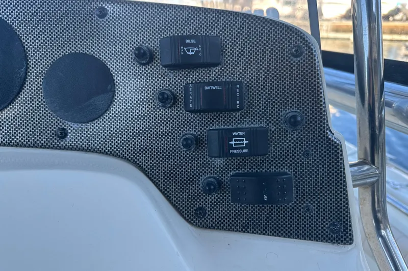 Slide: The Image of Control panel of a 2004 Scout 235 Sportfish boat with various switches. - 22