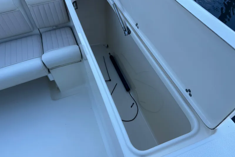 Slide: The Image of Open storage compartment on 2004 Scout 235 Sportfish boat, next to cushioned seating. - 28