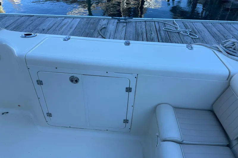 Slide: The Image of 2004 Scout 235 Sportfish boat interior with storage compartment and seating. - 29