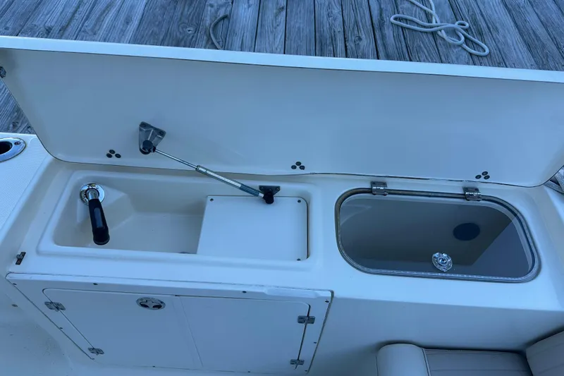 Slide: The Image of 2004 Scout 235 Sportfish boat with open storage compartment and livewell on deck. - 31