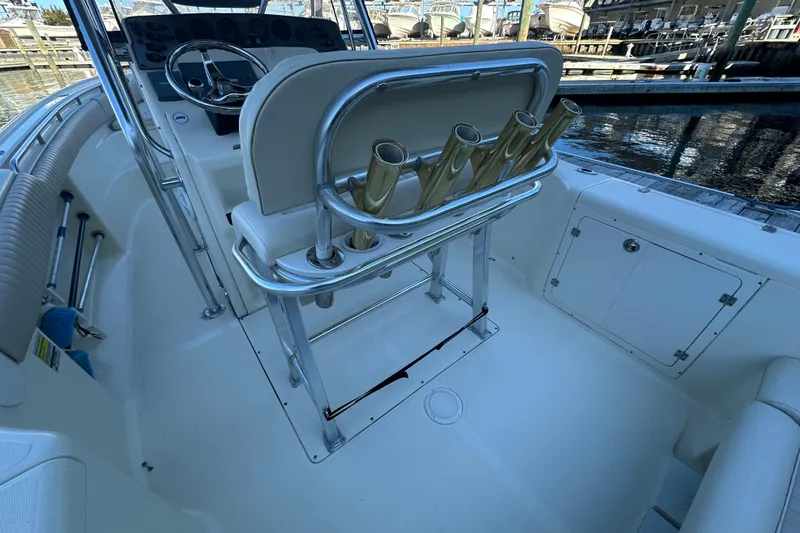 Slide: The Image of 2004 Scout 235 Sportfish boat interior with steering wheel and rod holders. - 33