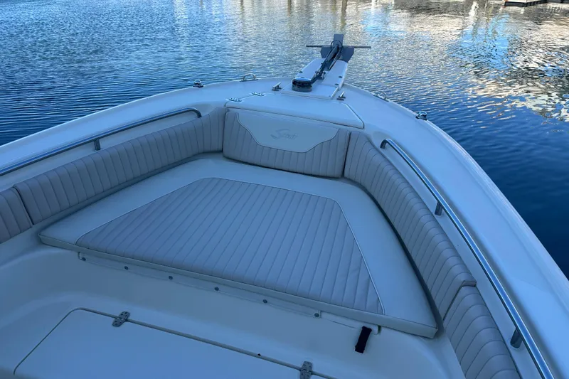Slide: The Image of 2004 Scout 235 Sportfish boat with cushioned seating on calm water. - 8