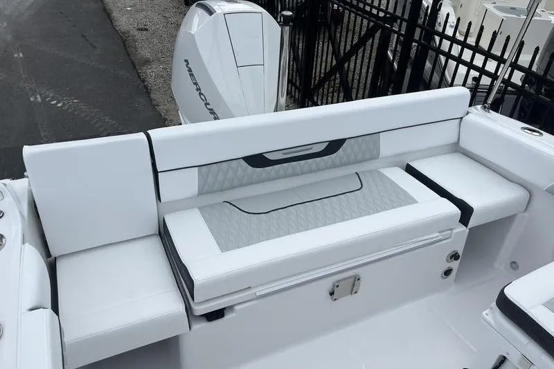 Slide: The Image of 2024 Blackfin 232 DC boat interior with white seating and Mercury engine. - 10