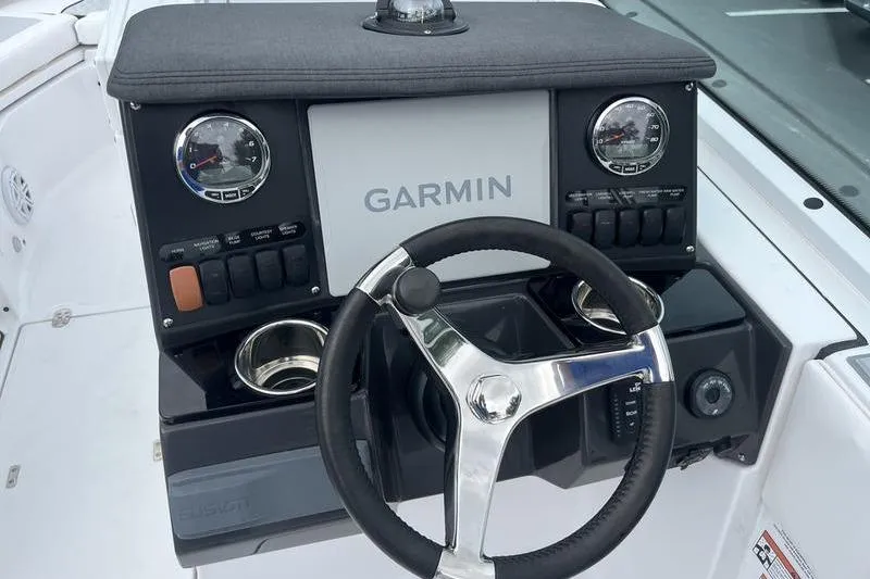 Slide: The Image of 2024 Blackfin 232 DC boat dashboard with Garmin display and steering wheel. - 12