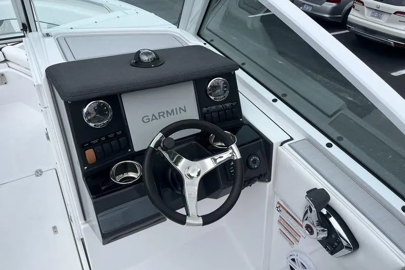 Slide: The Image of 2024 Blackfin 232 DC boat dashboard with Garmin navigation system and steering wheel. - 13