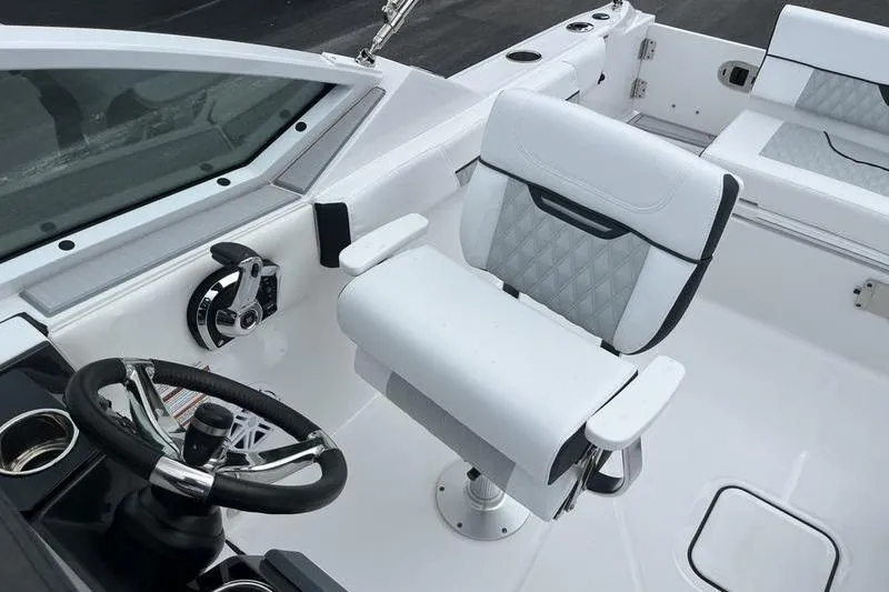 Slide: The Image of 2024 Blackfin 232 DC boat interior with steering wheel and white seating. - 14