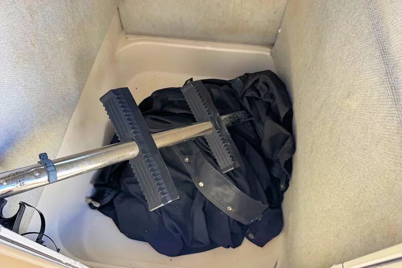 Slide: The Image of 2001 Bluewater 2350 boat interior with teal-accented seating and speakers, docked by lush greenery. - 11