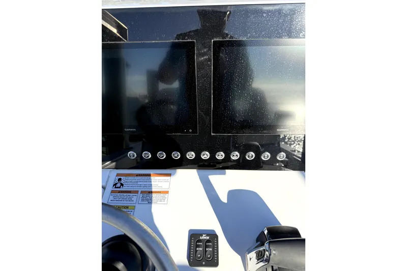 Slide: The Image of 2024 Contender 25 Bay boat dashboard with steering wheel and control panel. - 10