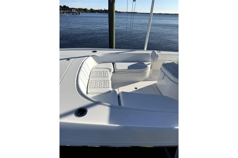 Slide: The Image of 2024 Contender 25 Bay boat interior with cushioned seating and water reflection. - 13