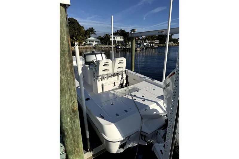 Slide: The Image of 2024 Contender 25 Bay boat interior with white cushioned seating by the water. - 14