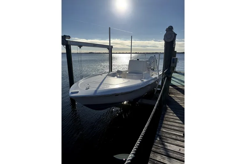 Slide: The Image of 2024 Contender 25 Bay boat docked at sunset on calm waters. - 2
