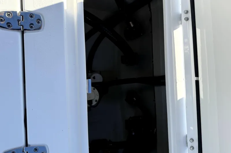 Slide: The Image of 2024 Contender 25 Bay boat storage compartment with wiring and equipment. - 21
