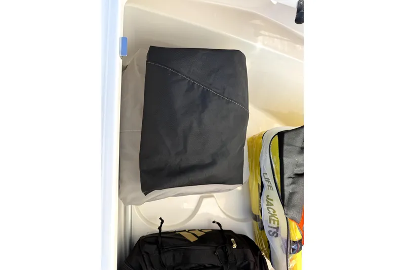 Slide: The Image of Storage compartment in 2024 Contender 25 Bay boat with life jackets and bags. - 24
