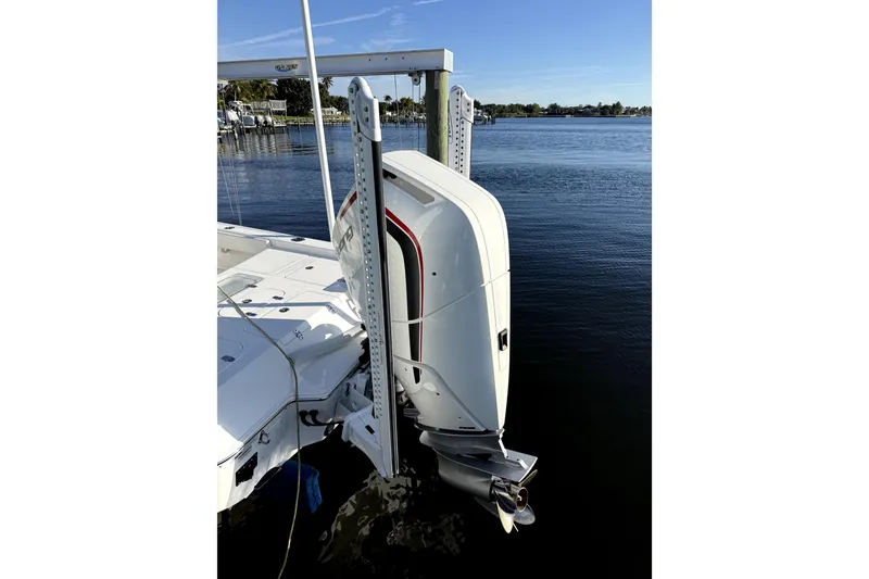 Slide: The Image of 2024 Contender 25 Bay boat with powerful outboard motor on calm water. - 6