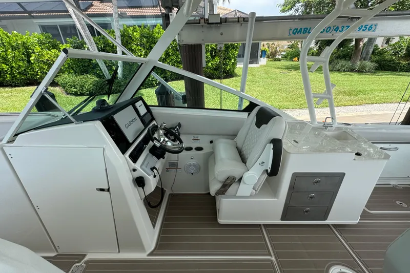 Slide: The Image of 2021 Sailfish 276 DC boat interior with steering wheel and seating area. - 12