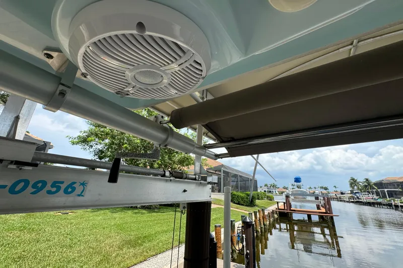 Slide: The Image of 2021 Sailfish 276 DC boat speaker and dock view with lush greenery. - 16