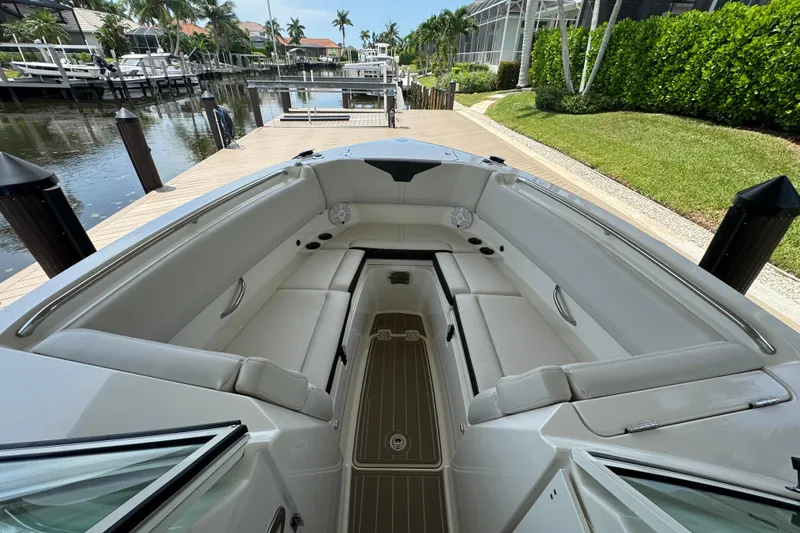 Slide: The Image of 2021 Sailfish 276 DC boat interior with spacious seating, docked by a canal. - 18