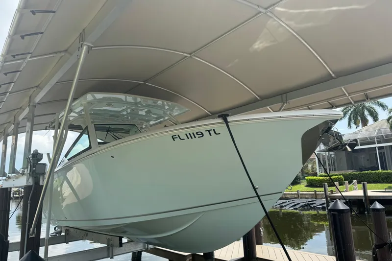 Slide: The Image of 2021 Sailfish 276 DC boat docked under canopy, side view. - 2