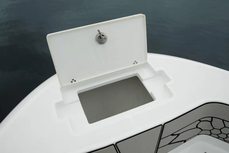 Slide: The Image of 2025 Wellcraft 202 Fisherman boat storage compartment open on calm water. - 12