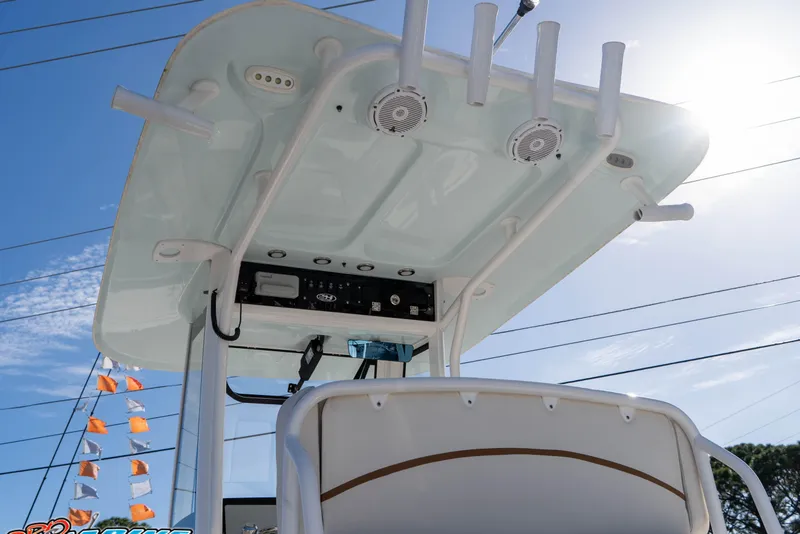 Slide: The Image of 2022 Sea Hunt Ultra 239 SE boat console with rod holders and speakers under sunny sky. - 17