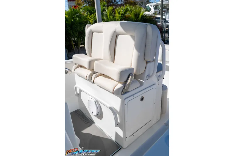 Slide: The Image of 2022 Sea Hunt Ultra 239 SE boat seating with white cushioned seats and storage compartment. - 21