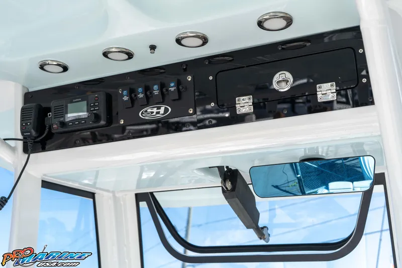 Slide: The Image of 2022 Sea Hunt Ultra 239 SE console with controls and radio equipment. - 25