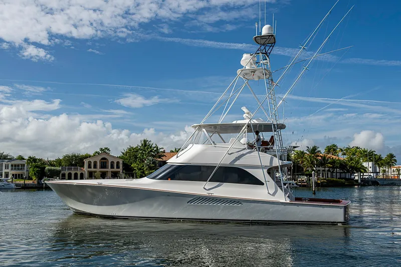 The Image of 2007 Viking 64 Convertible yacht cruising on a sunny day near waterfront homes. - 1