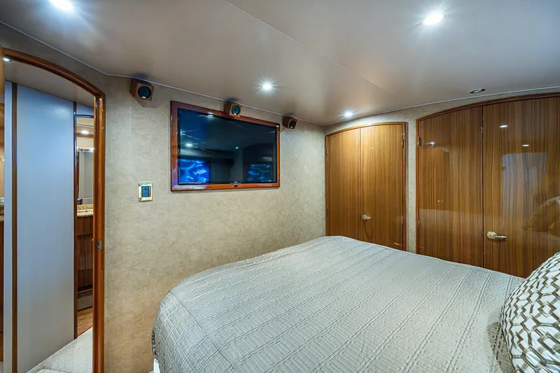 Slide: The Image of Luxurious bedroom interior of 2007 Viking 64 Convertible yacht with TV and wooden doors. - 17