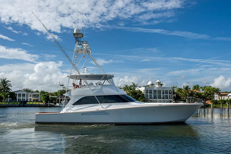 Slide: The Image of 2007 Viking 64 Convertible yacht cruising on a sunny day near luxury waterfront homes. - 2