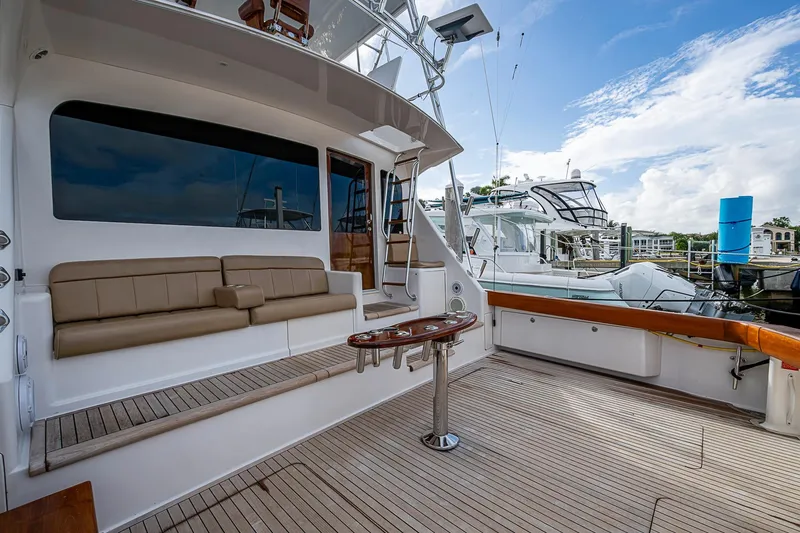 Slide: The Image of 2007 Viking 64 Convertible yacht deck with seating and table, docked at marina. - 26