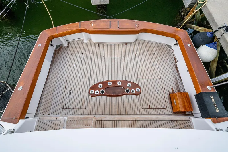 Slide: The Image of 2007 Viking 64 Convertible yacht deck with wooden finish and fishing rod holders. - 31