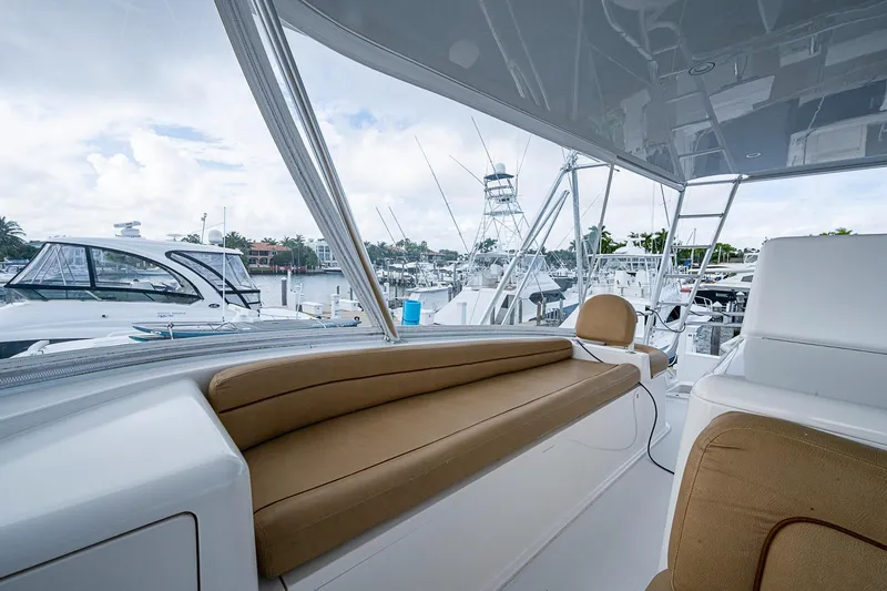 Slide: The Image of 2007 Viking 64 Convertible yacht interior with tan seating, docked at marina. - 38