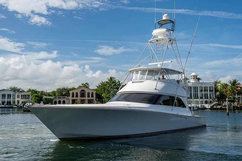 Slide: The Image of 2007 Viking 64 Convertible yacht on calm water, with luxury homes in the background. - 4