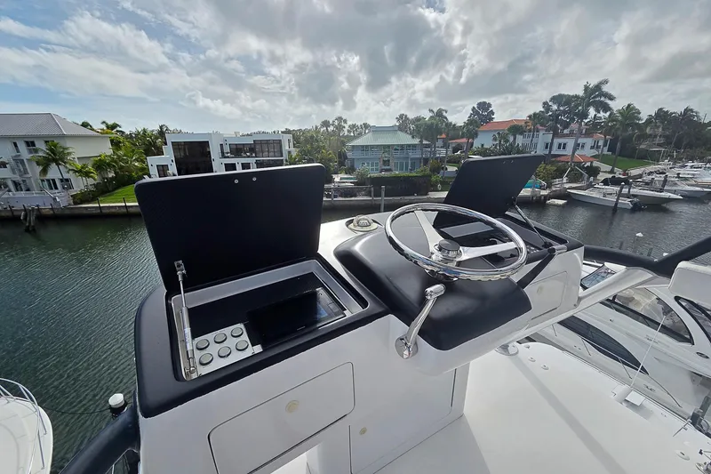 Slide: The Image of 2007 Viking 64 Convertible yacht helm with waterfront view and modern controls. - 40