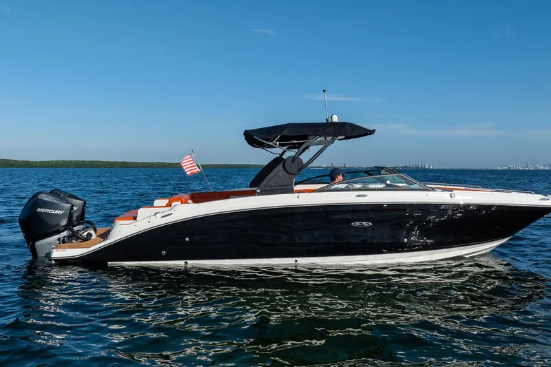 Slide: The Image of 2019 Sea Ray SDX 290 Outboard boat cruising on open water under clear blue sky. - 14