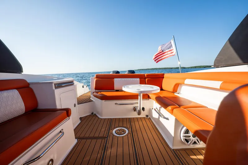 Slide: The Image of 2019 Sea Ray SDX 290 Outboard boat interior with orange seating and American flag. - 25