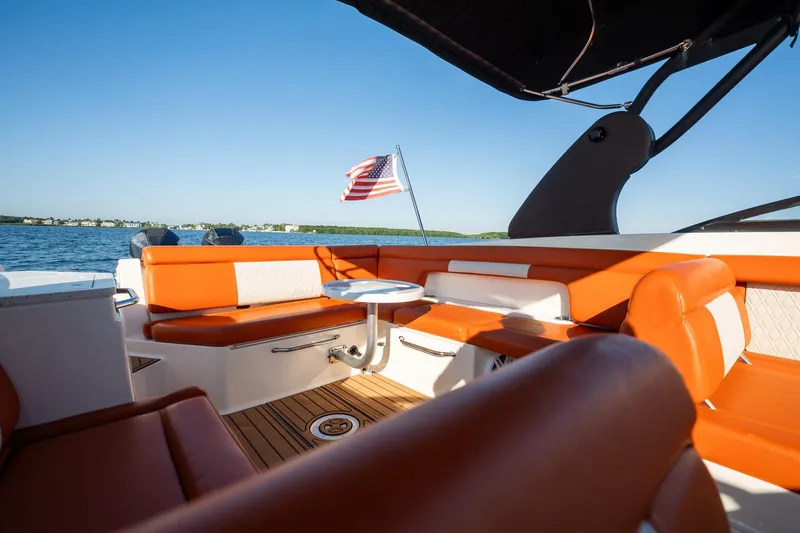 Slide: The Image of 2019 Sea Ray SDX 290 Outboard boat interior with orange seating and American flag. - 34