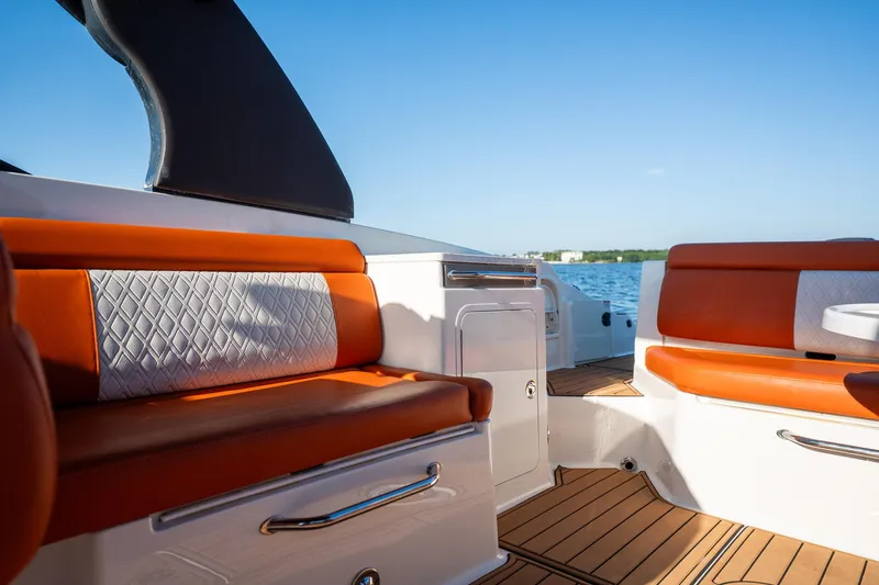 Slide: The Image of 2019 Sea Ray SDX 290 Outboard interior with orange seating and wood flooring. - 35