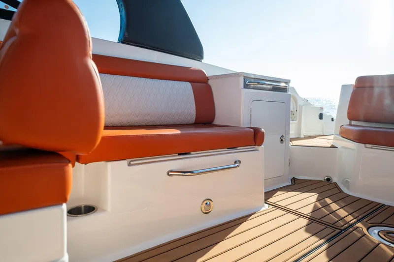 Slide: The Image of 2019 Sea Ray SDX 290 Outboard interior with orange seating and teak flooring. - 36