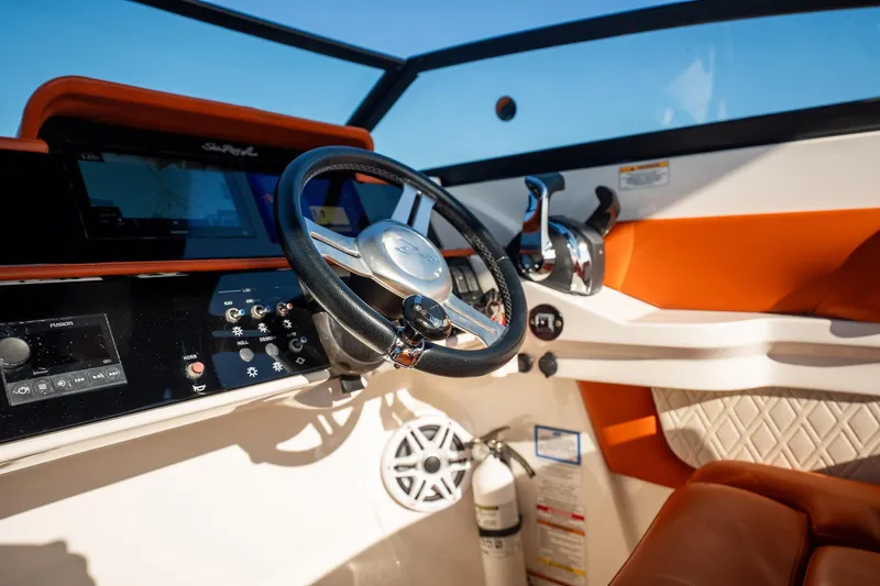 Slide: The Image of 2019 Sea Ray SDX 290 Outboard helm with steering wheel, controls, and navigation display. - 40