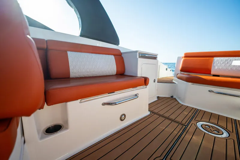 Slide: The Image of 2019 Sea Ray SDX 290 Outboard interior with orange seating and teak flooring. - 56