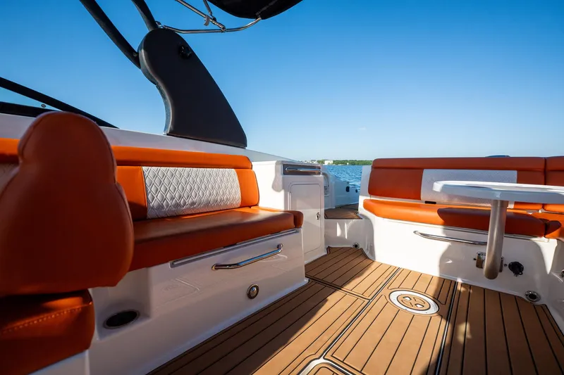 Slide: The Image of 2019 Sea Ray SDX 290 Outboard interior with orange seating and wooden deck. - 57