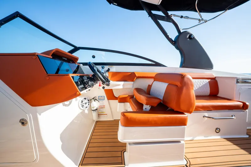 Slide: The Image of 2019 Sea Ray SDX 290 Outboard interior with orange seating and modern dashboard. - 58