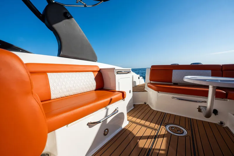 Slide: The Image of 2019 Sea Ray SDX 290 Outboard interior with orange seating and ocean view. - 63