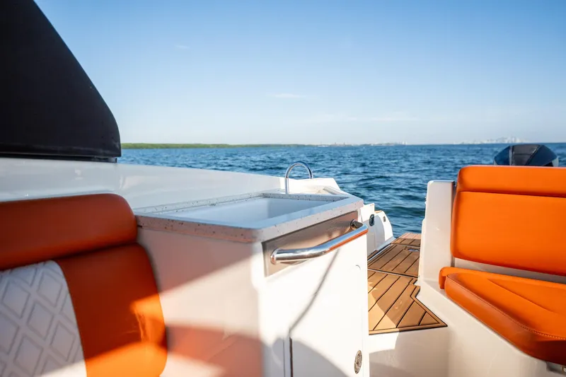 Slide: The Image of 2019 Sea Ray SDX 290 Outboard boat interior with orange seating and ocean view. - 65