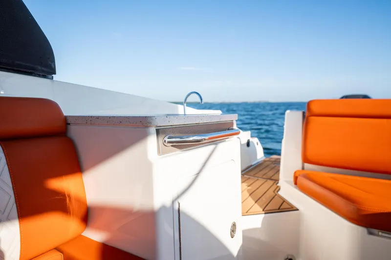 Slide: The Image of 2019 Sea Ray SDX 290 Outboard interior with orange seating and ocean view. - 66