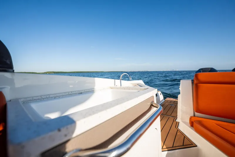 Slide: The Image of 2019 Sea Ray SDX 290 Outboard boat with orange seating, cruising on open water. - 67